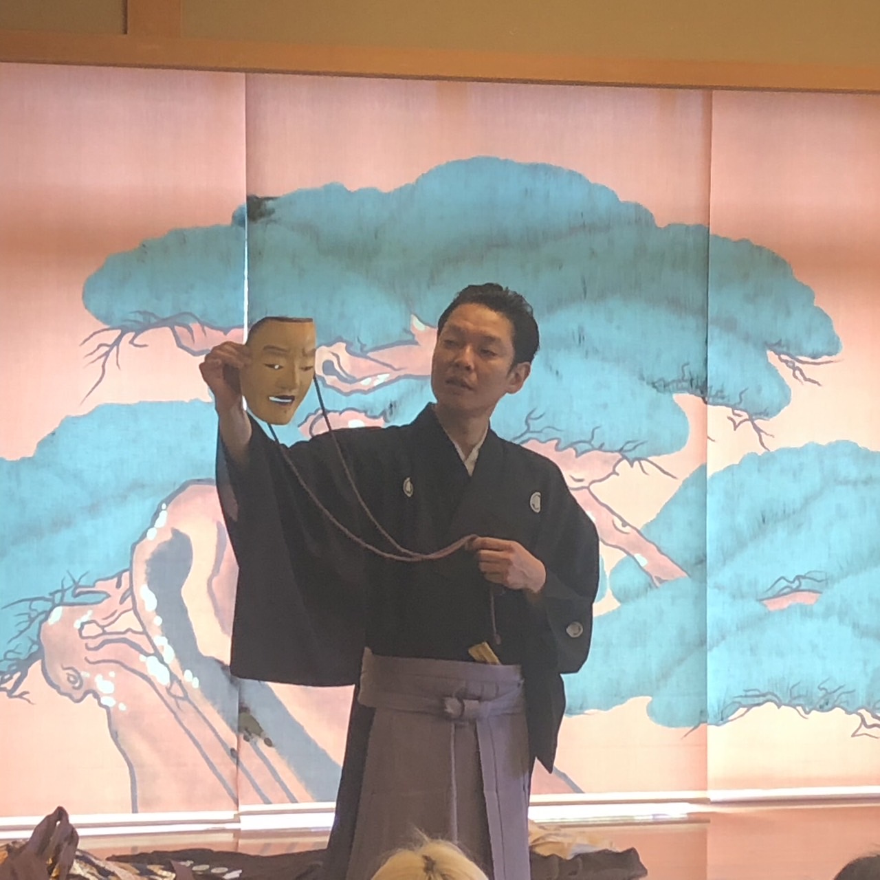 能面を手に舞台に立つ能楽師